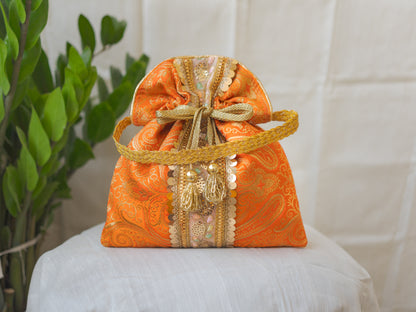 Pumpkin Orange & Golden Banarasi Potli Bag With Broad Lace