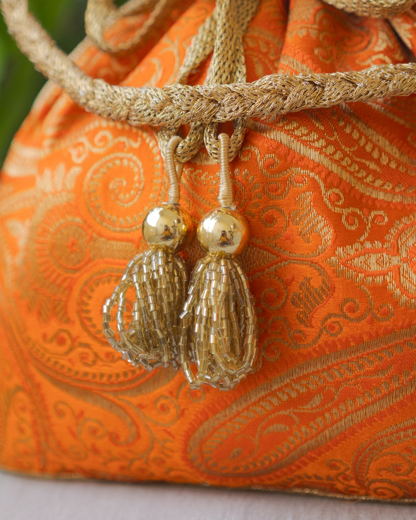 Pumpkin Orange & Golden Banarasi Potli With Glass Tassels