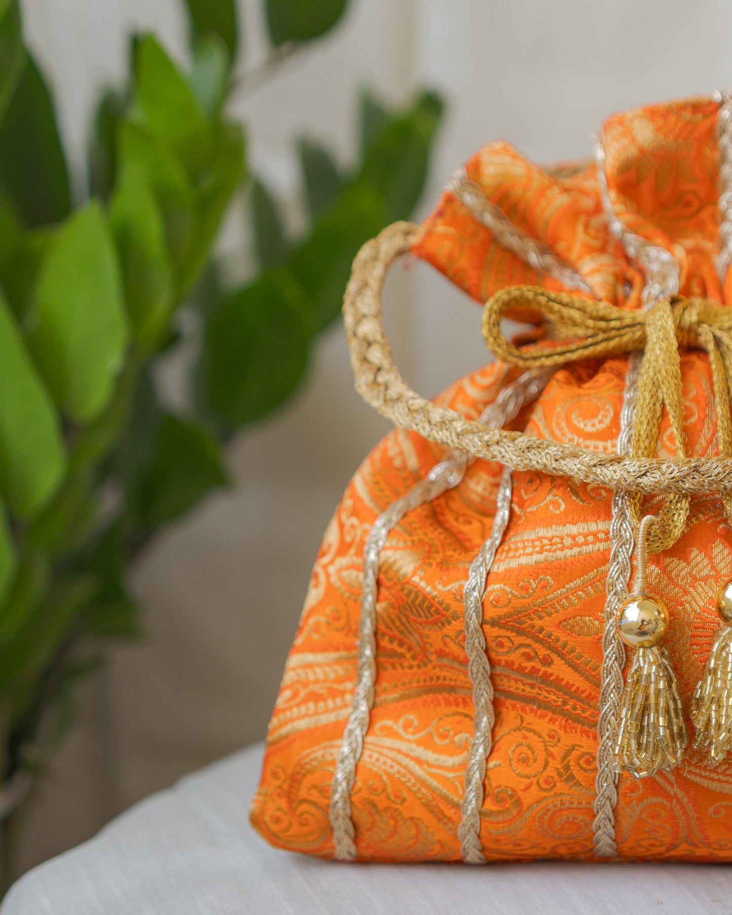 Pumpkin Orange & Golden Banarasi Potli With Glass Tassels