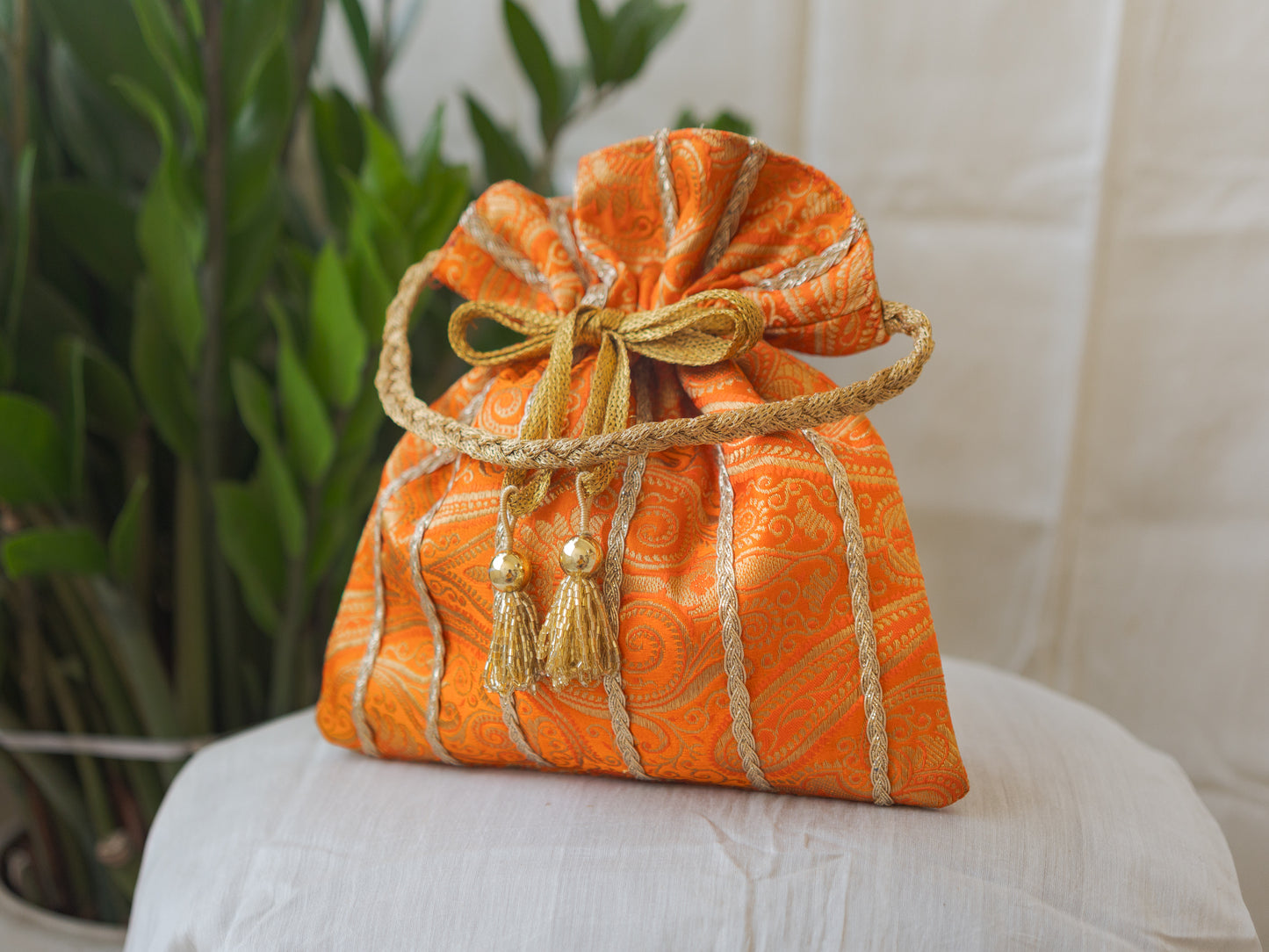 Pumpkin Orange & Golden Banarasi Potli With Glass Tassels