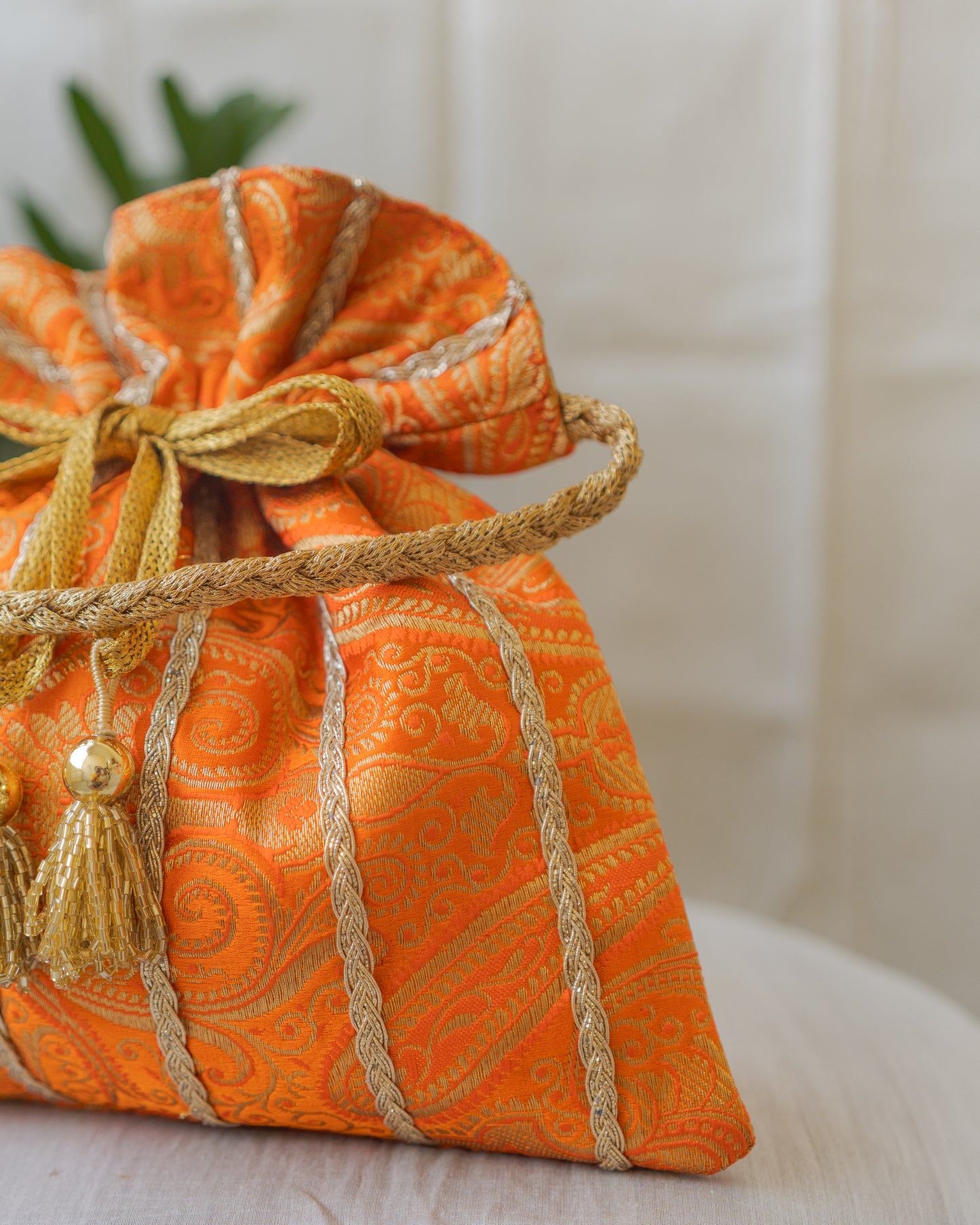 Pumpkin Orange & Golden Banarasi Potli With Glass Tassels