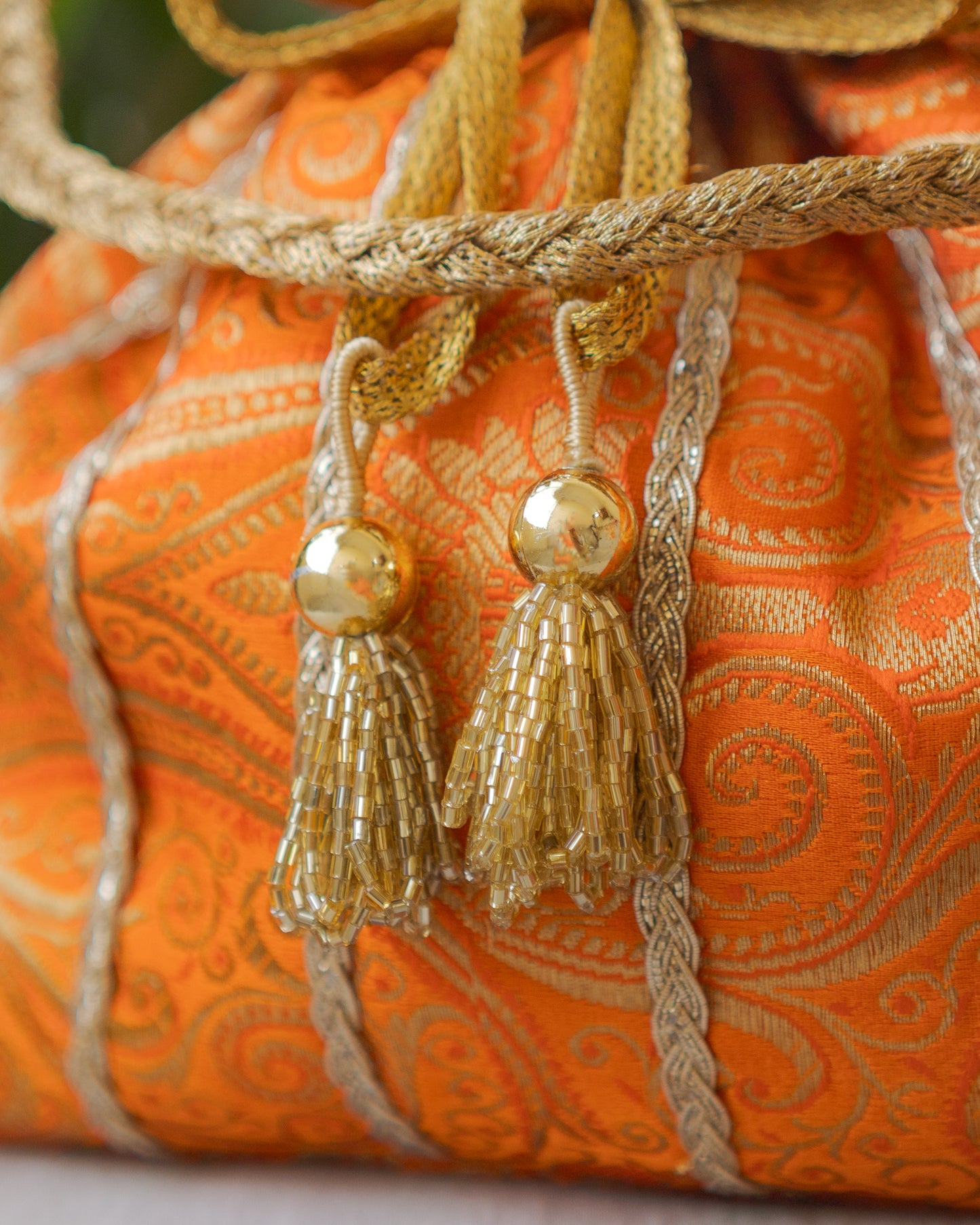 Pumpkin Orange & Golden Banarasi Potli With Glass Tassels